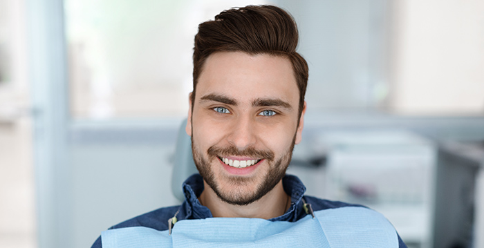 lächelnder Mann zur Prophylaxe beim Zahnarzt