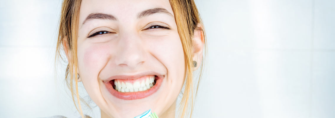 Frau lacht als Symbol für professionelle Zahnreinigung