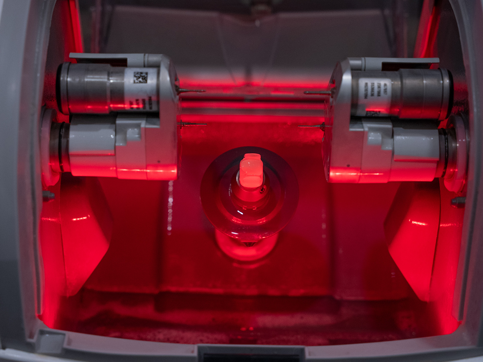 Innenansicht eines technischen Geräts mit roten LED-Lichtern und metallischen Komponenten.